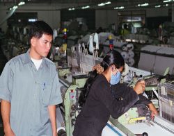 Manager supervising workers in factory