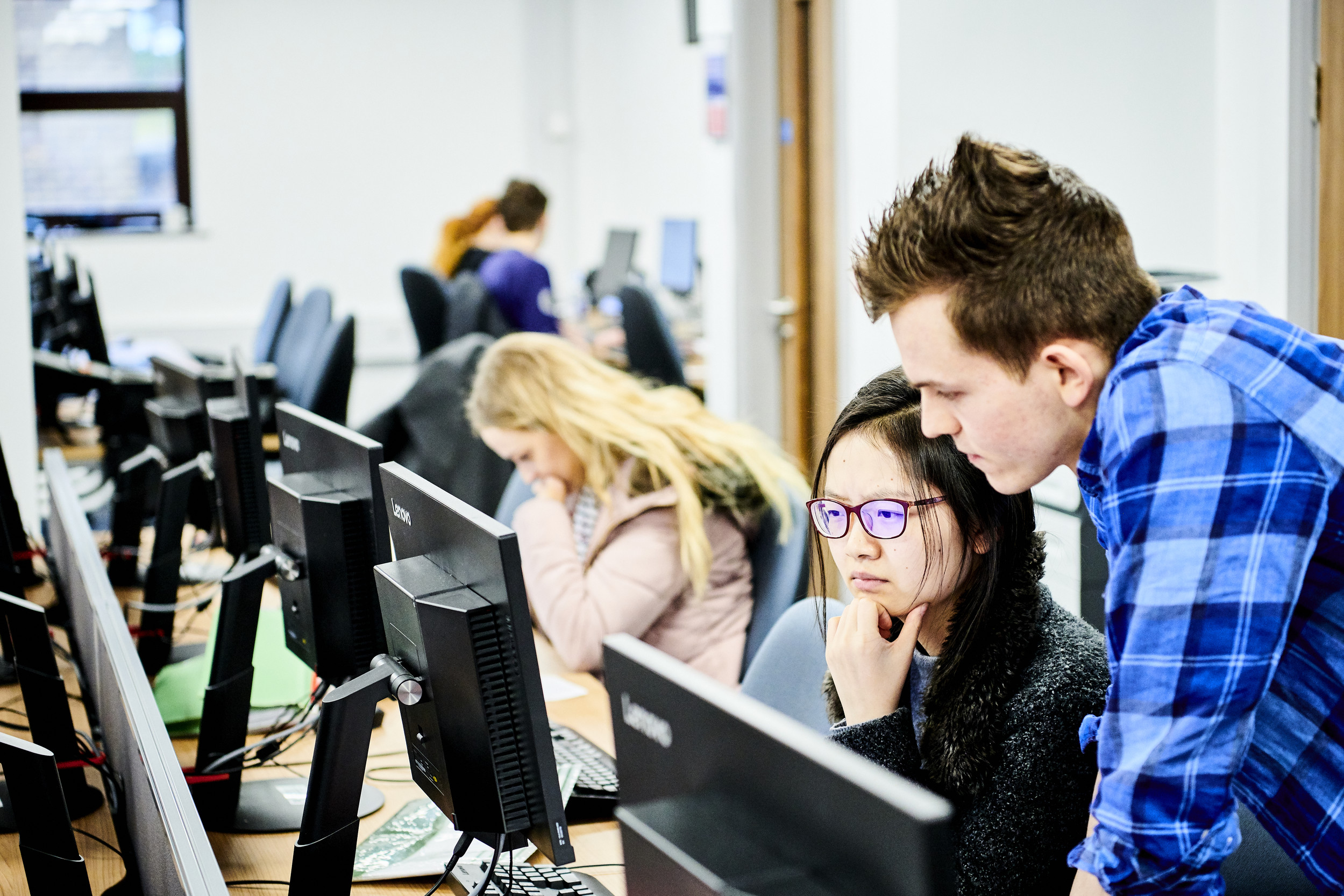 Two students working together at a computer.