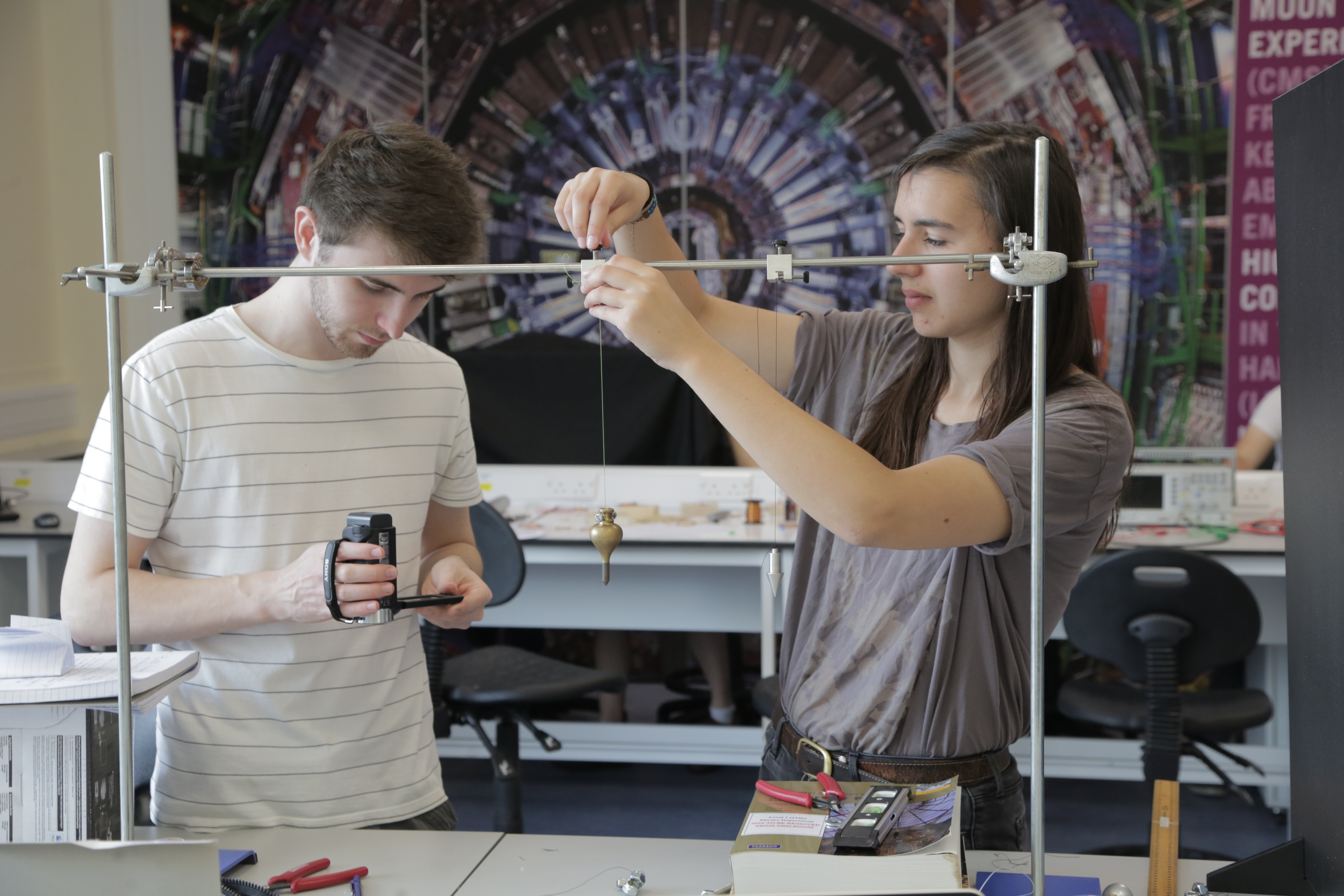 2 students undertake a bifilar pendulum experiment
