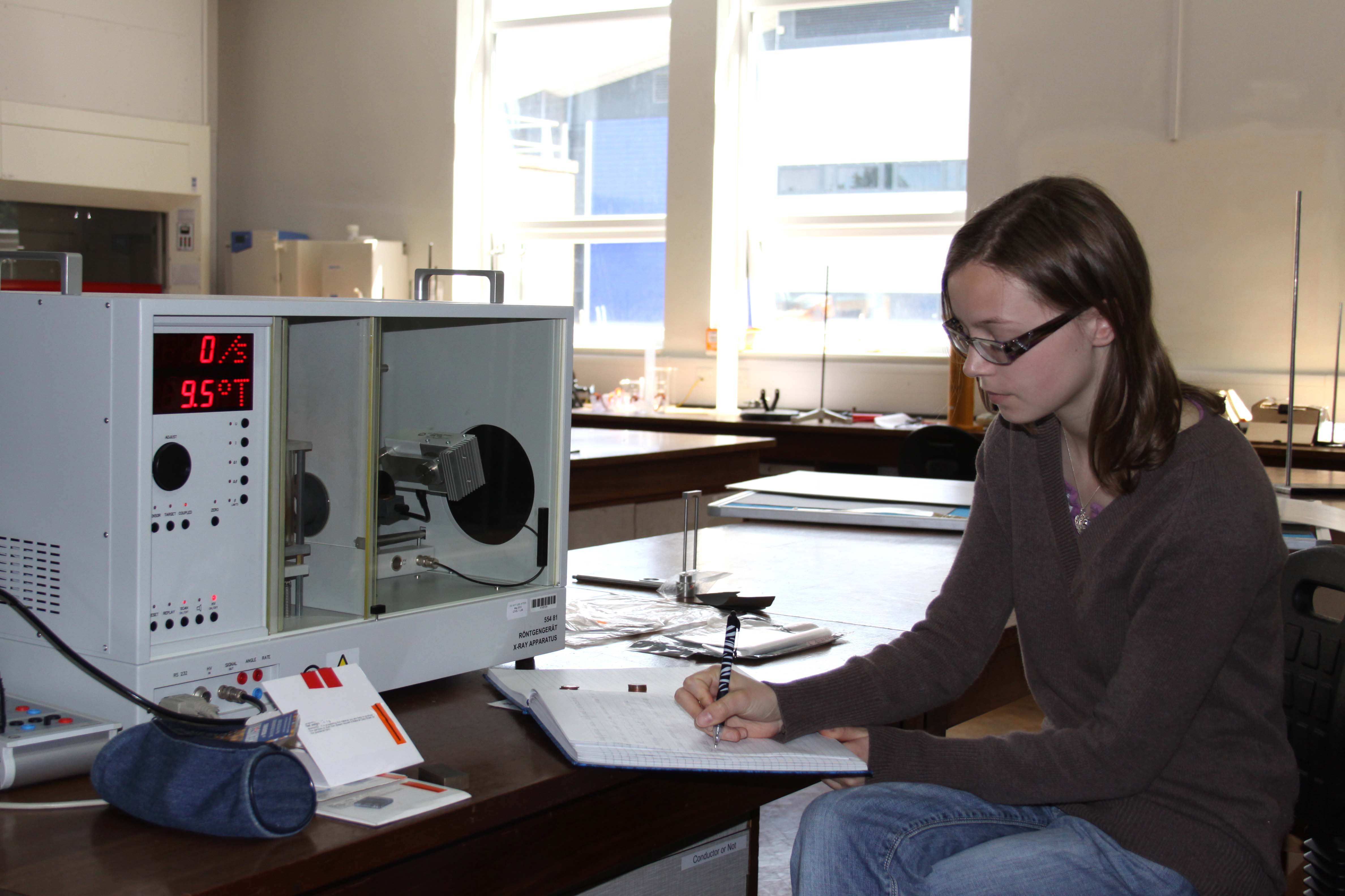 Student in lab making notes for a project