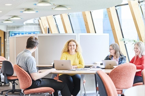 Four postgraduate students working together in an open study space