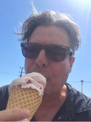 Headshot of a professor eating ice cream