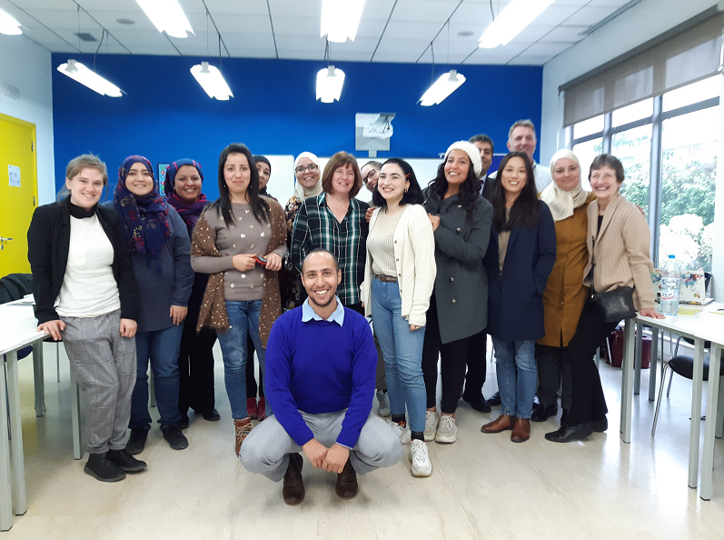 Cluster of staff and students taking a group photo in a classroom