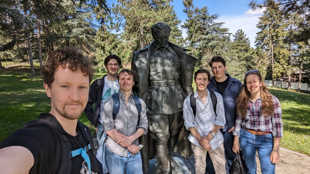 Selfie of six people with a statue