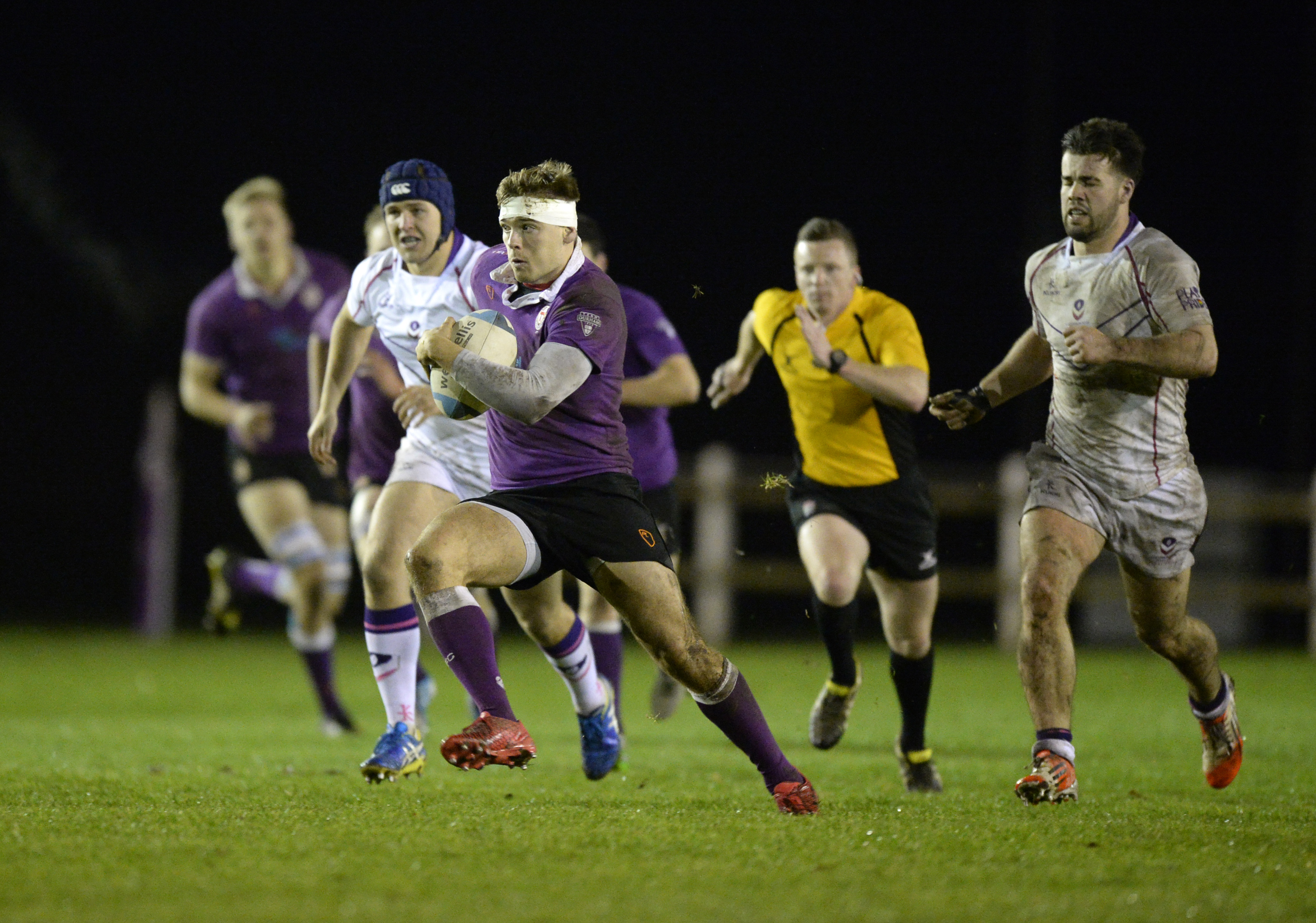 TGroup of men playing a game of rugby on a pitch