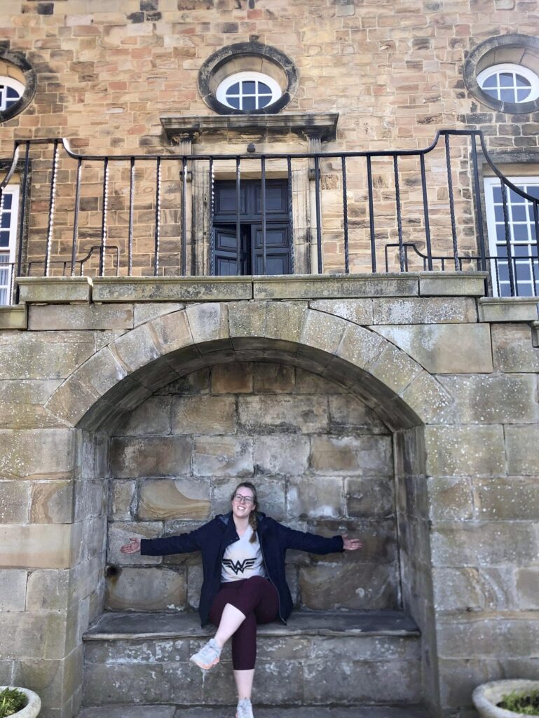 female student sitting in stone archway
