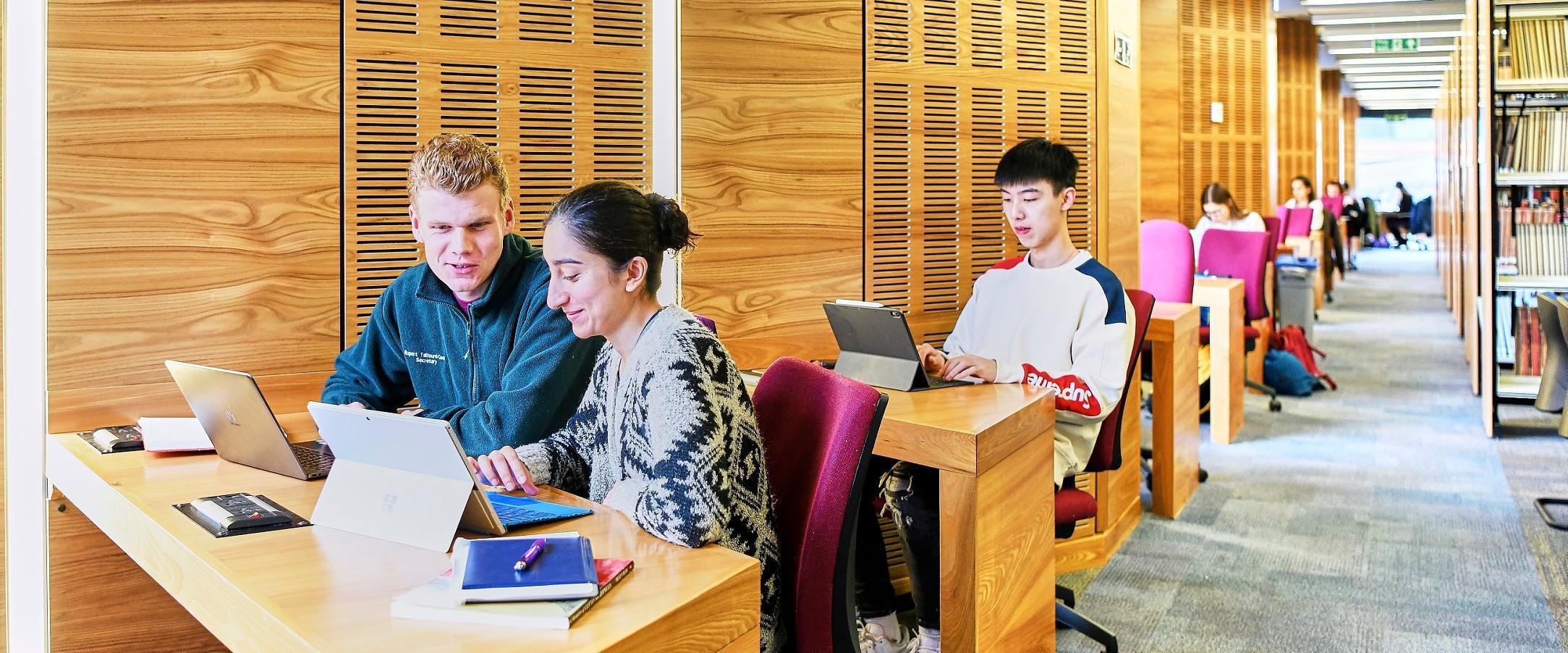 Students studying at desks inside the library