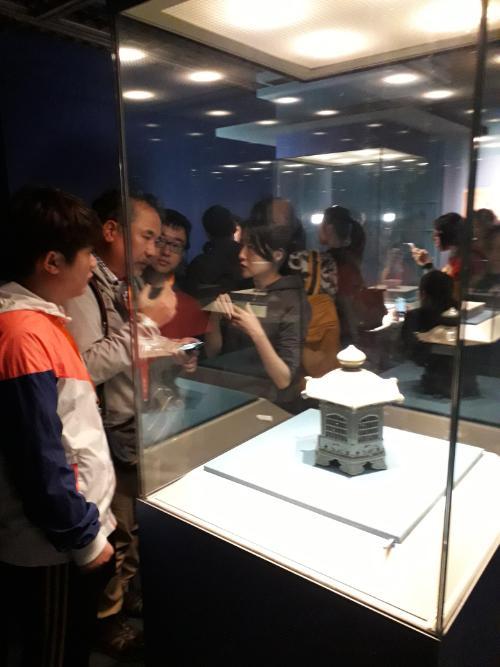 Visitors to the Lonquan of the World exhibition look at a lantern on loan from the Oriental Museum