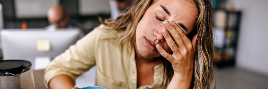 A woman looking stressed out with her hand over her face