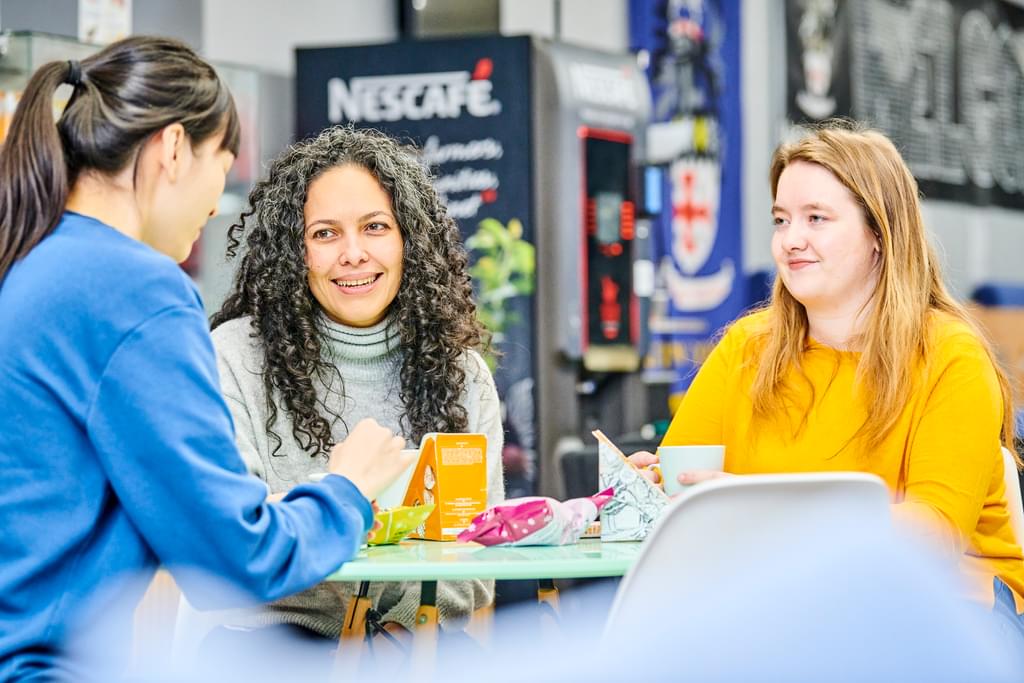 A small group of mature students talking and smiling
