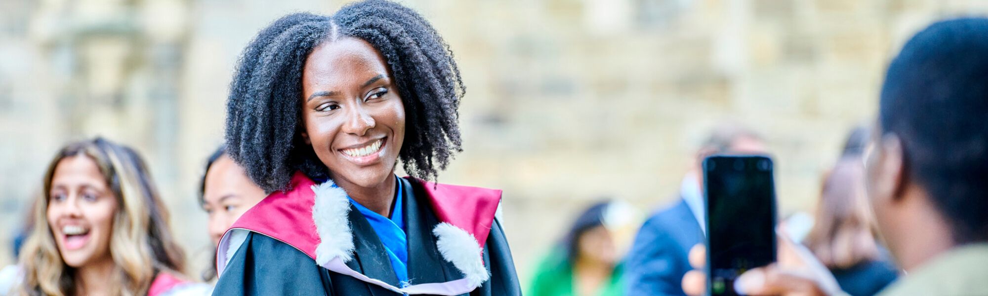 Graduate in academic dress posing for a photo