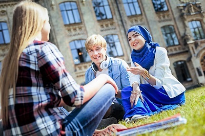 TThree students talking while sitting outside