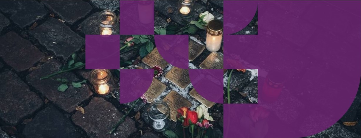 Lit candles on ground with purple tapestry