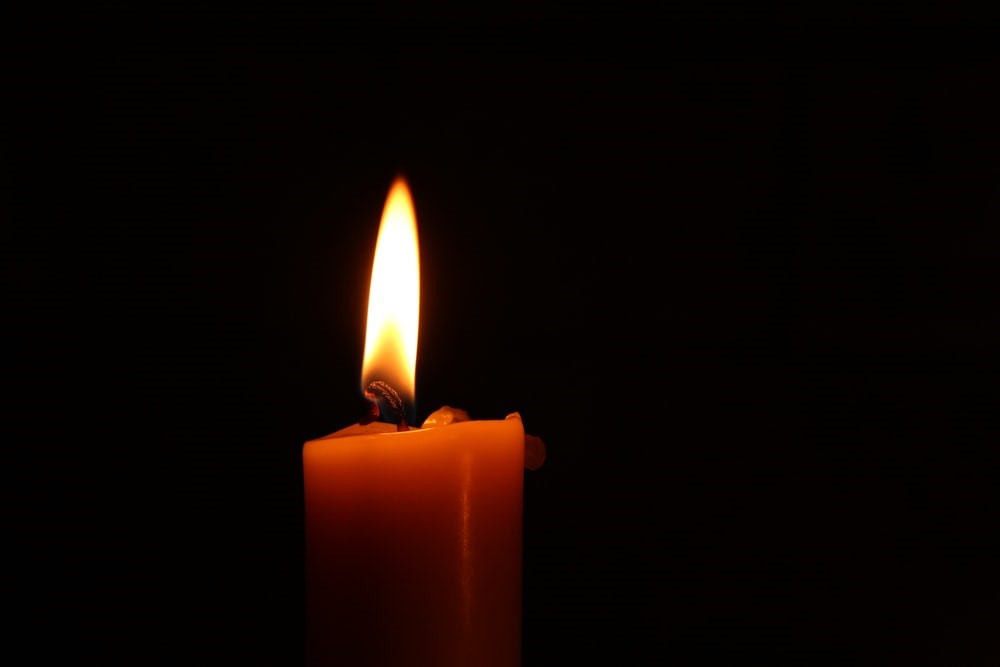 A burning candle on a black background