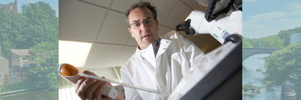 Scientist in lab coat using a pipette on Durham underlay