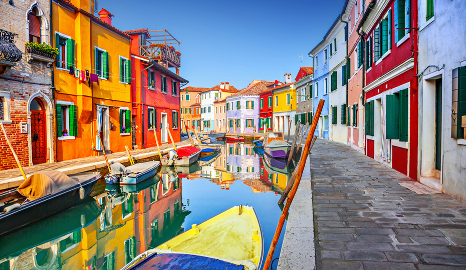 A canal in Burano, Italy lined with colourful buildings