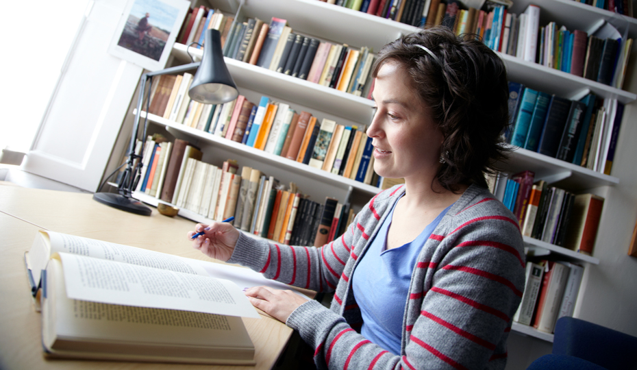 A person studying a book and making notes