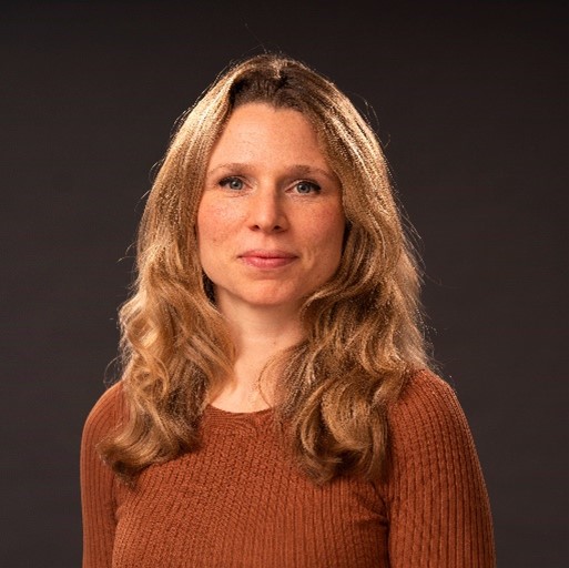 Natalie Dobson with blonde wavy hair smiling at the camera