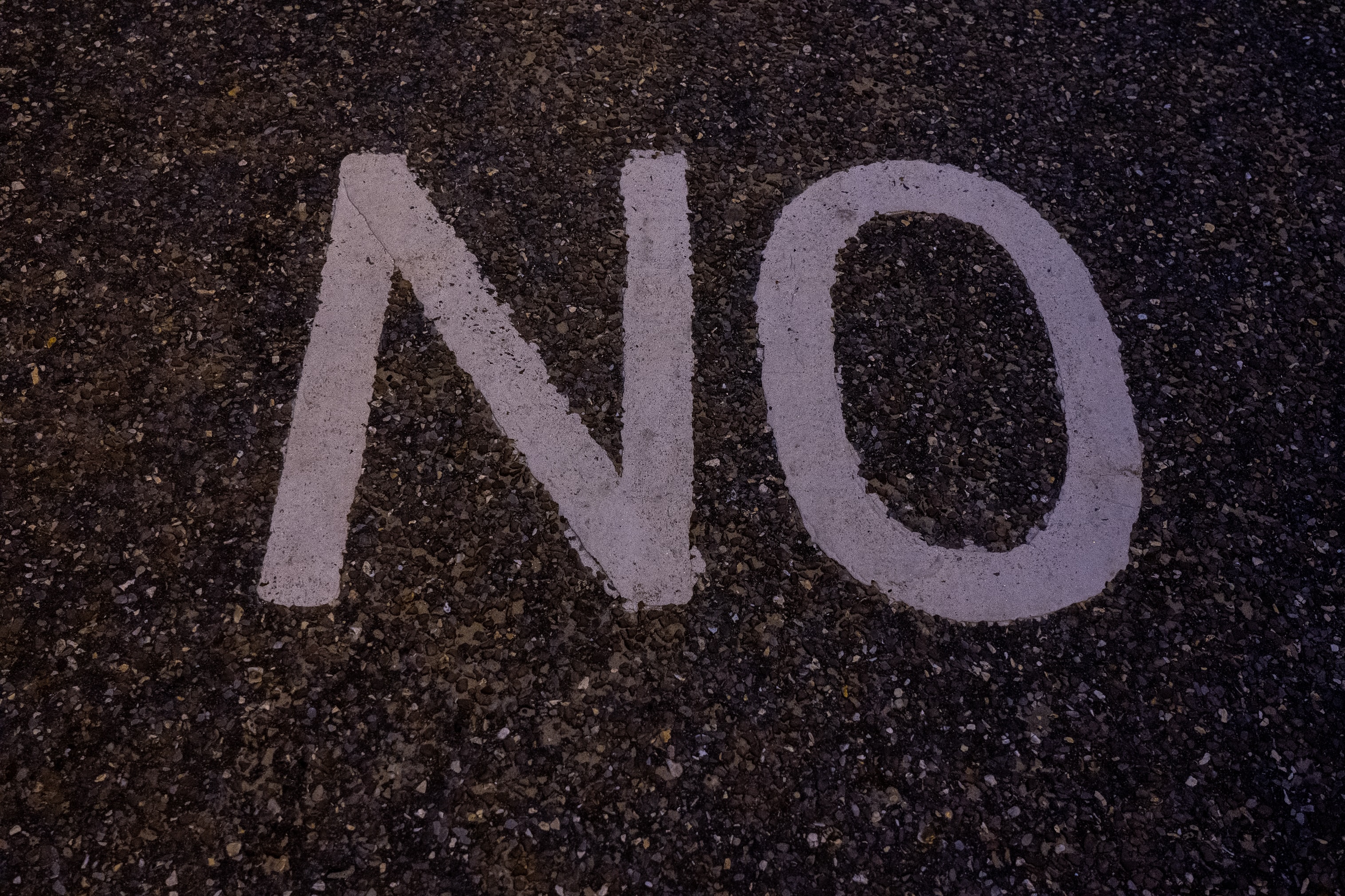The word 'no' painted on a tar road