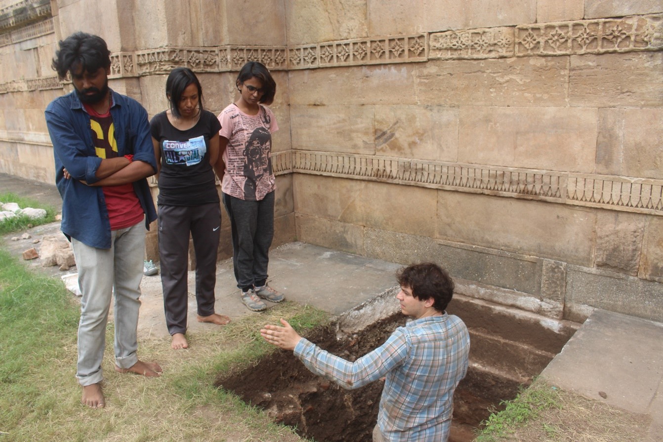 Explaining an archaeological trench to students
