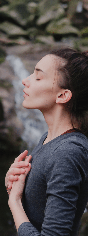 A woman with her hands on her chest breathing deep