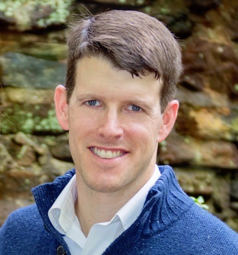 A smiling man with short brown hair