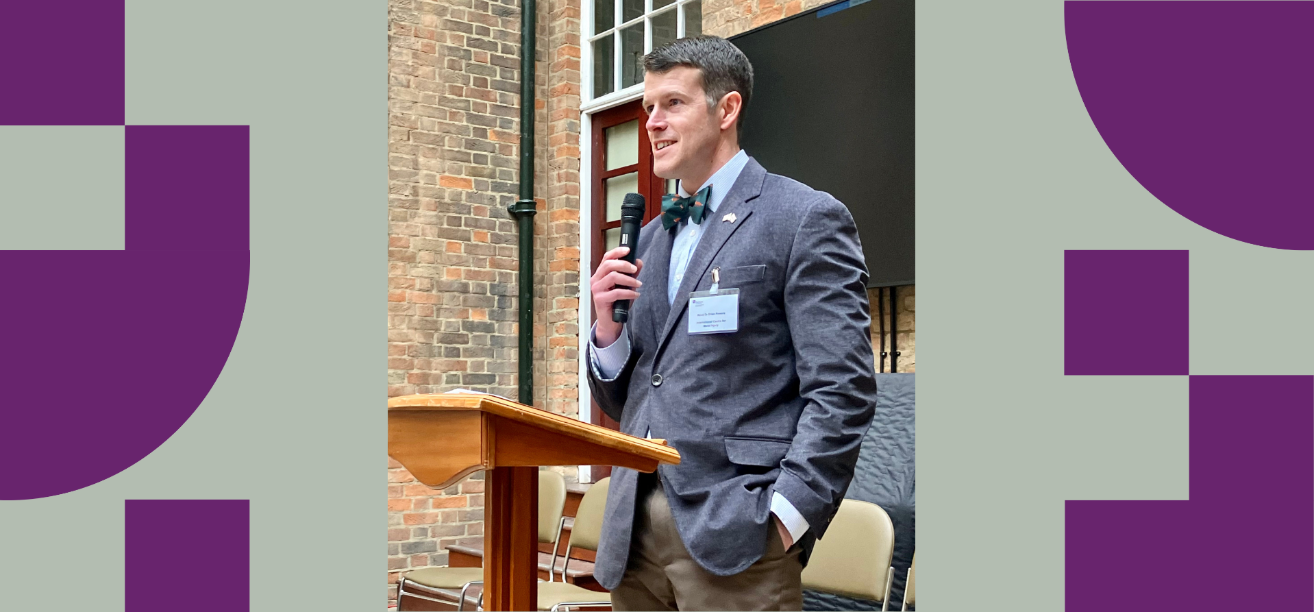 A man in a suit at a lectern with a microphone