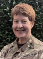 A woman with short red hair wearing British military uniform with a badge saying 