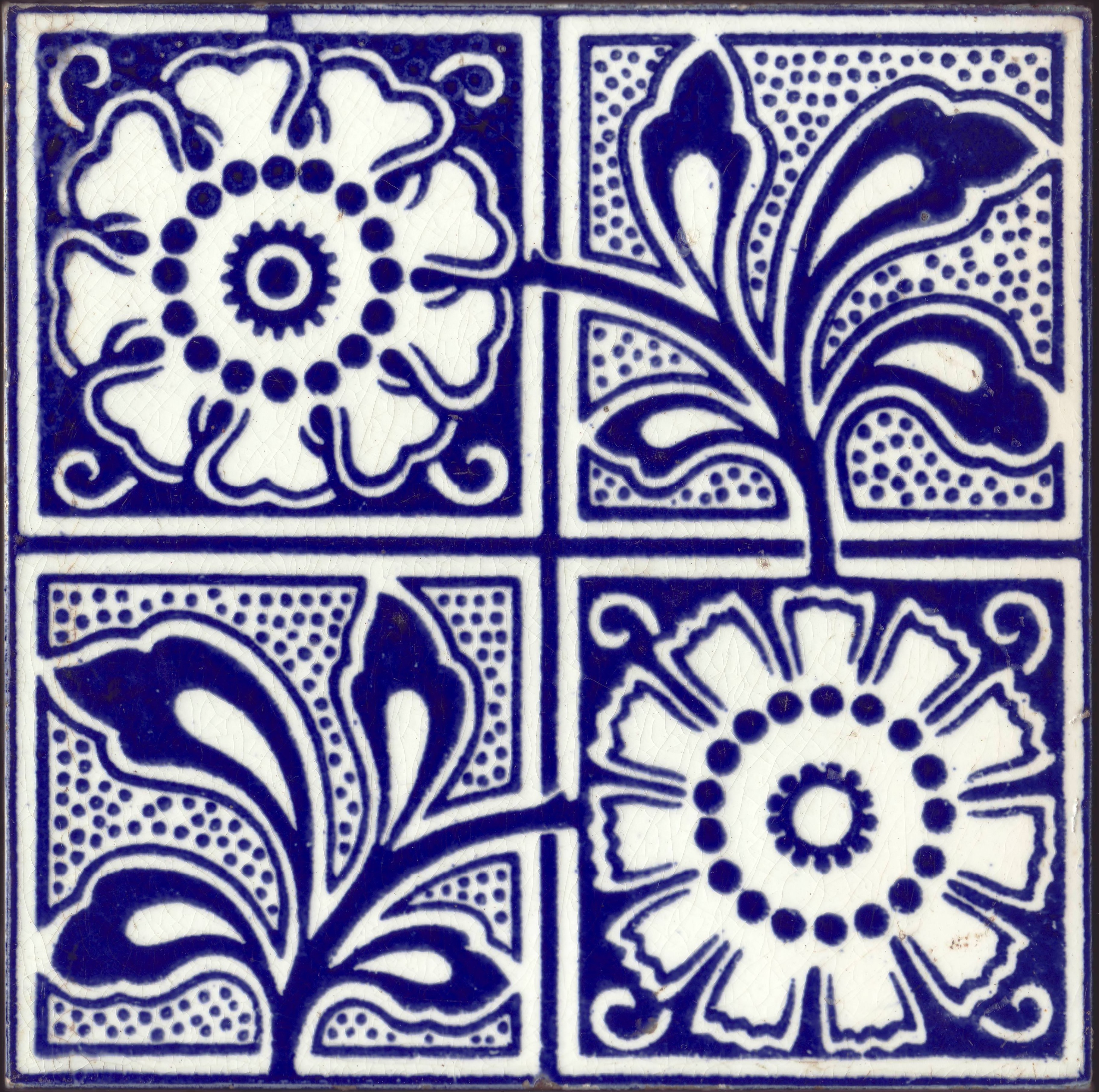 Victorian tile with blue and white patterning depicting leaf and flower patterns