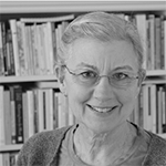 Black and white image of a smiling white woman with grey hair and glasses