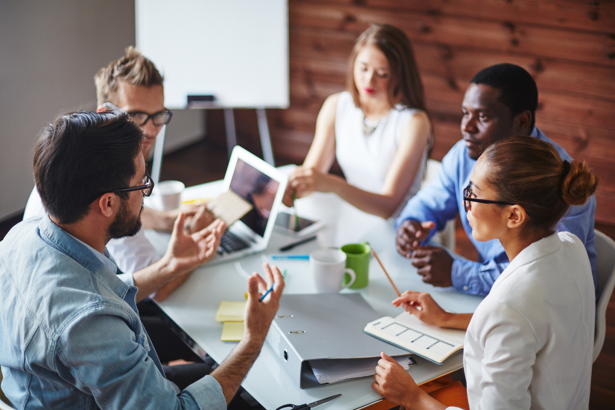 Five people sat conversing around a table together