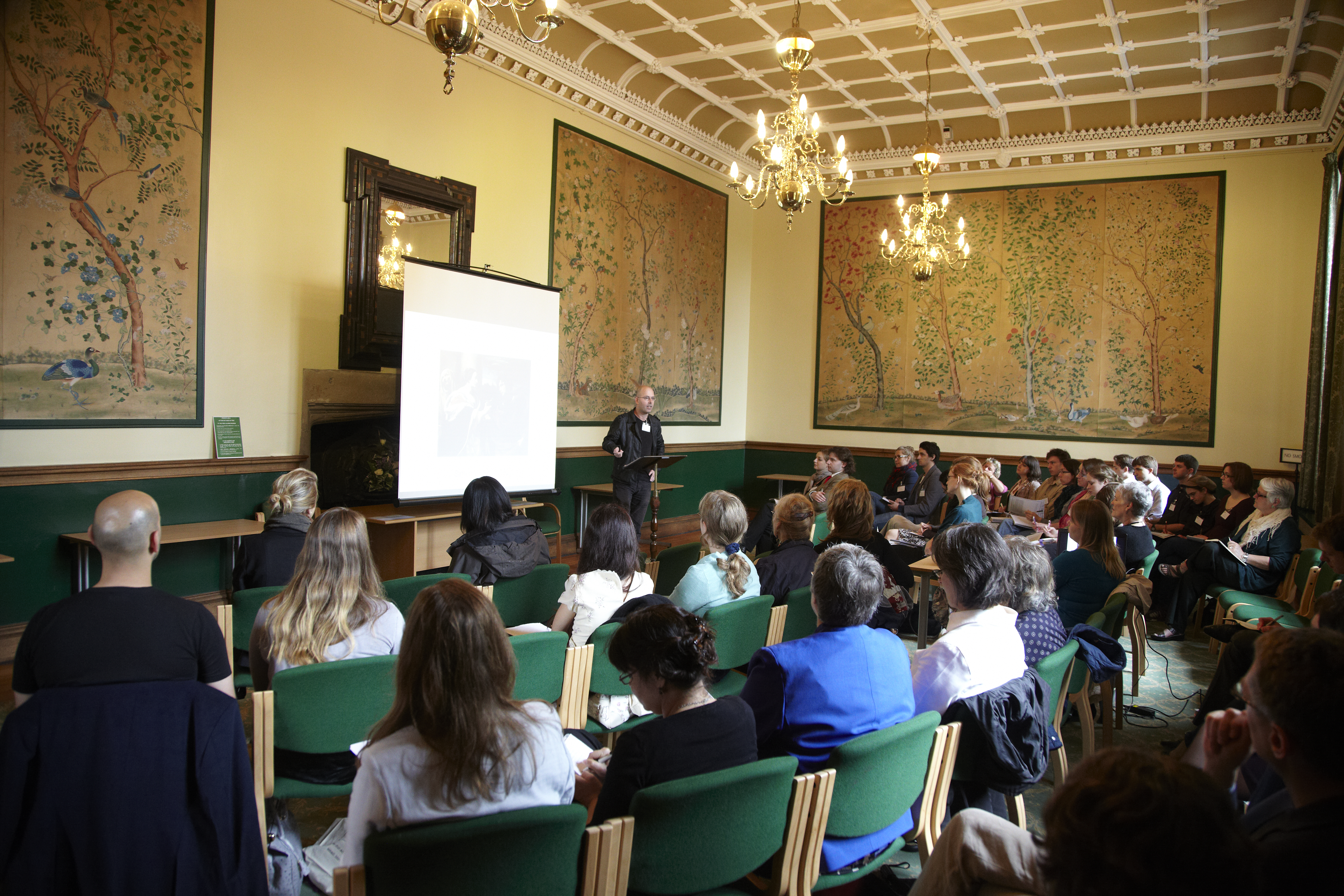 a room of people sitting down listening to a lecture