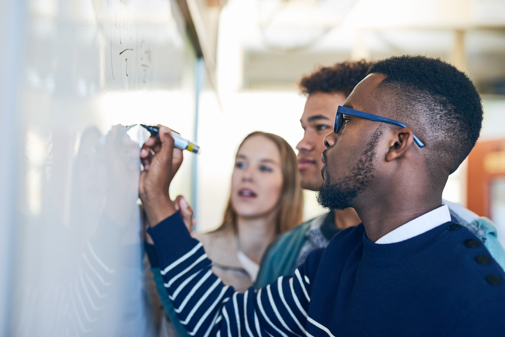 Students writing on a white board