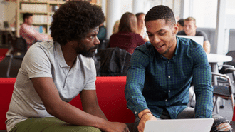 Two students looking at a laptop