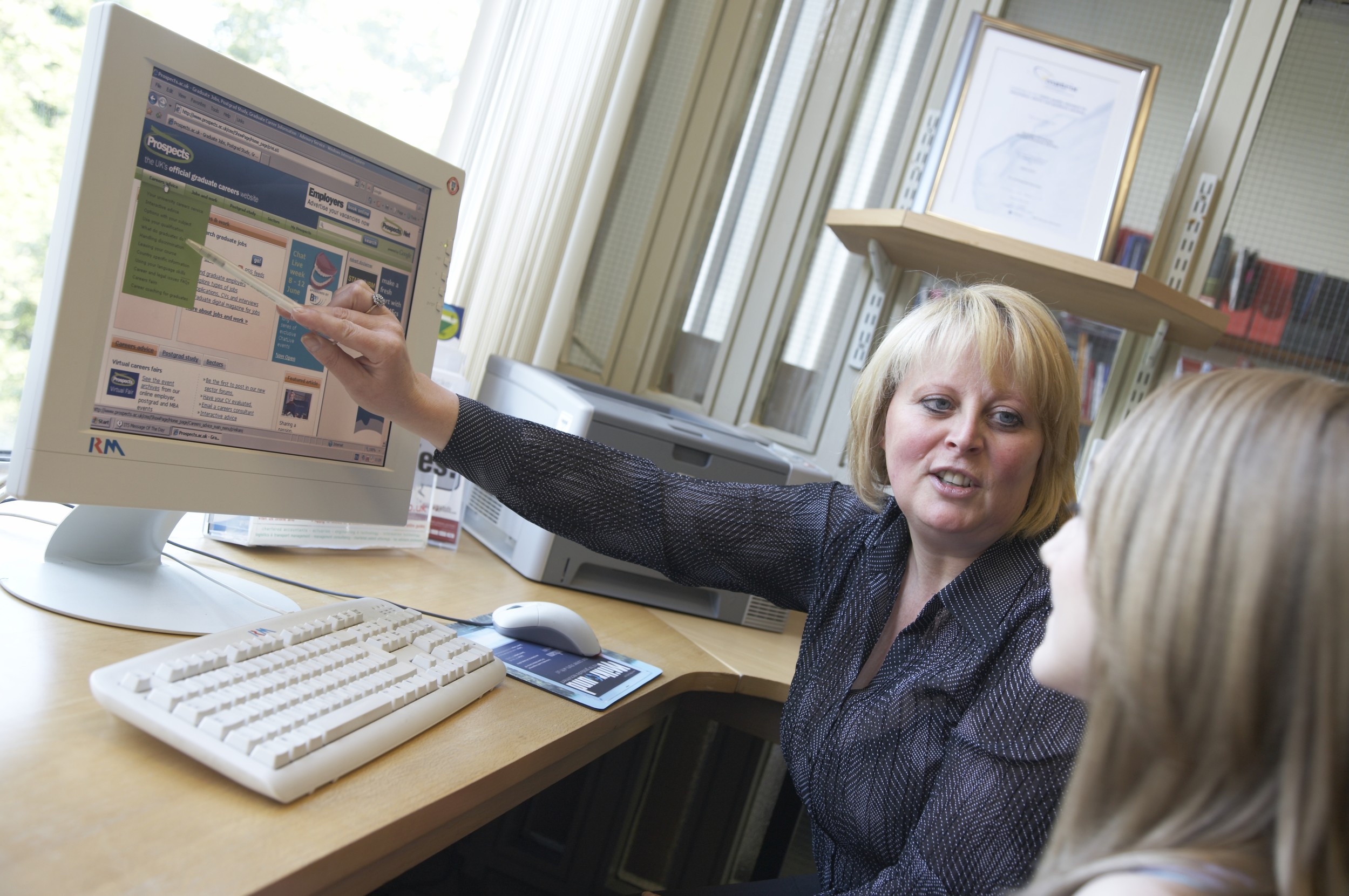 TA Careers and Employability advisor assisting a student at a computer