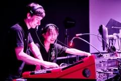 Two students working on equipment in a recording studio