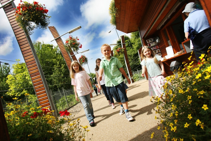 A group of three children walking through the Botanic Garden