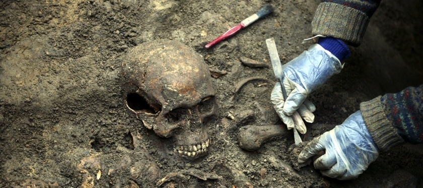 Archaeologists uncovering a skeleton