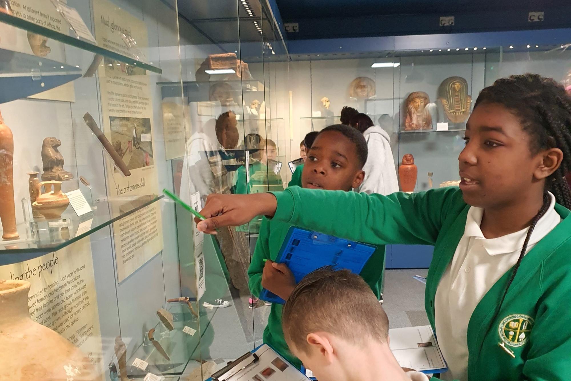 School children exploring in a museum and pointing at the exhibitions