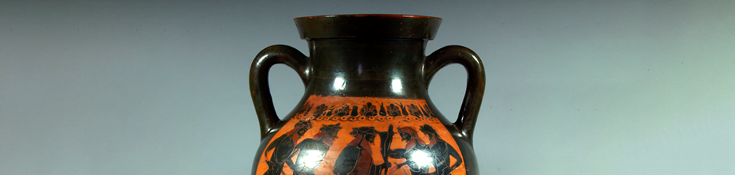 Close-up view of a glazed Greek pot featuring a god speaking with a group of satyrs