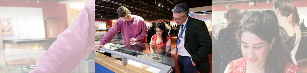 Three people are looking at a piece of art within a glass museum case.
