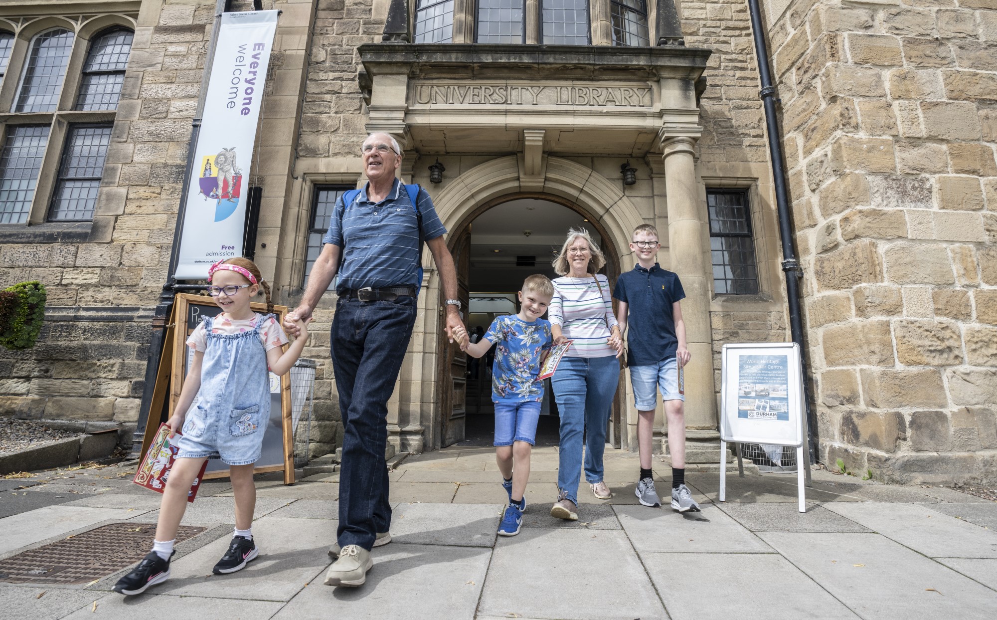 A family exiting Palace Green Library.