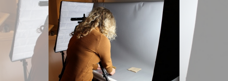 Photograph of a volunteer at the Museum of Archaeology working with the collection.