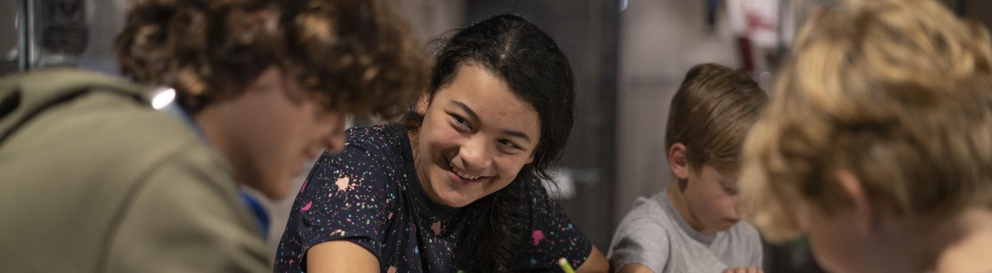 Young people sat around a craft table smiling