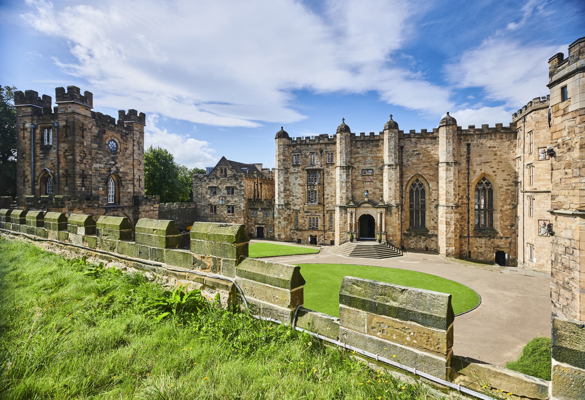 The courtyard of Durham Castle on a bright day with blue sky.