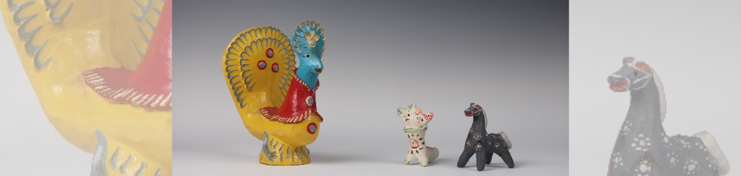 Group of three toys, one is a large yellow and blue rooster, and the smaller two are a black horse and a white fantasy creature with two heads.